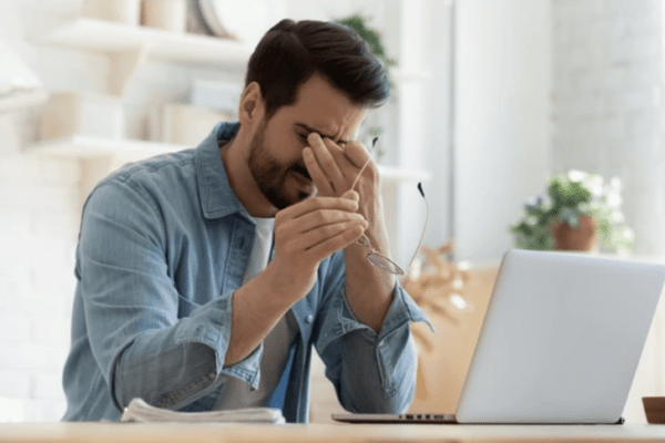 Frustrated man at laptop in Chicago office, representing the need for expert IT support services.