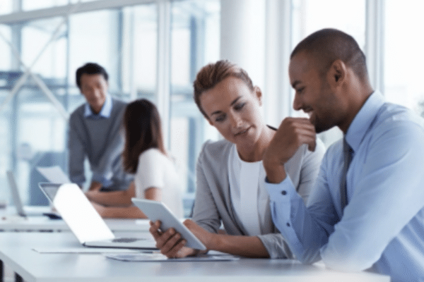 Business professionals reviewing CMMC compliance documents with GO Technology Group cybersecurity consultants.