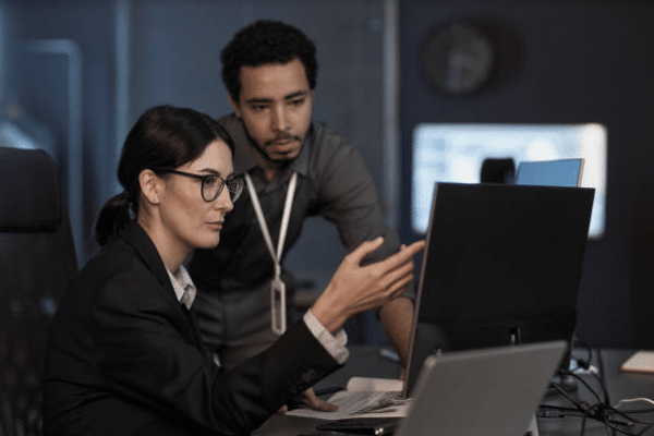 In What Ways Does AI Contribute to Startup Scalability (2) IT specialists analyzing data security and AI governance frameworks in a secure operations center, guided by GO Technology Group.