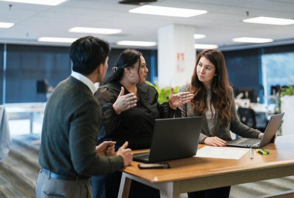 12 Positive Cultural Shifts in Companies Embracing AI (2) Professionals collaborating in a modern office environment as part of AI-driven digital transformation and workplace culture