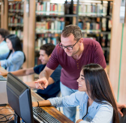Library staff receiving technology support at public computers to improve secure and accessible digital services