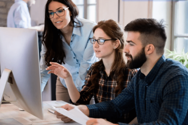 Employees collaborating during cybersecurity awareness training to reduce human risk and strengthen organizational security