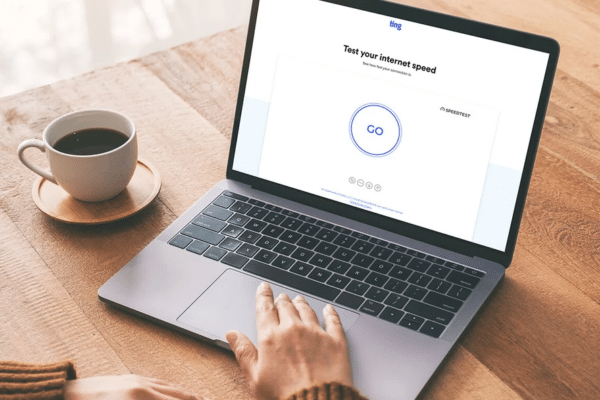 Laptop displaying an internet speed test on a desk workspace