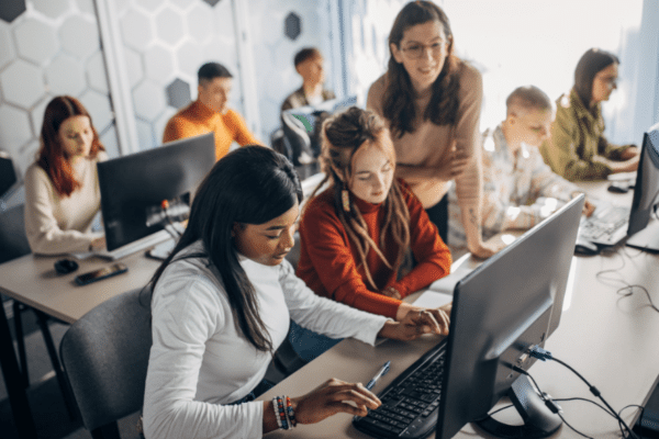 Students using computers in a classroom, highlighting digital learning and school cybersecurity environments