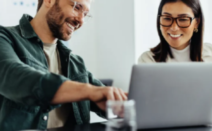 Two professionals collaborating on a laptop, representing outsourced IT support and business partnership in Chicago