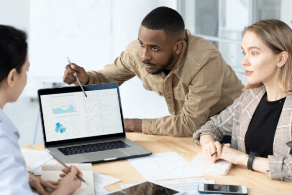 Business professionals reviewing workflow data and business process automation metrics during a team planning meeting