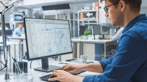 Construction professional reviewing project drawings on screen for document version control