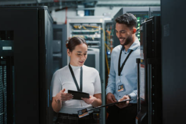 IT professionals reviewing IT performance metrics in a server room